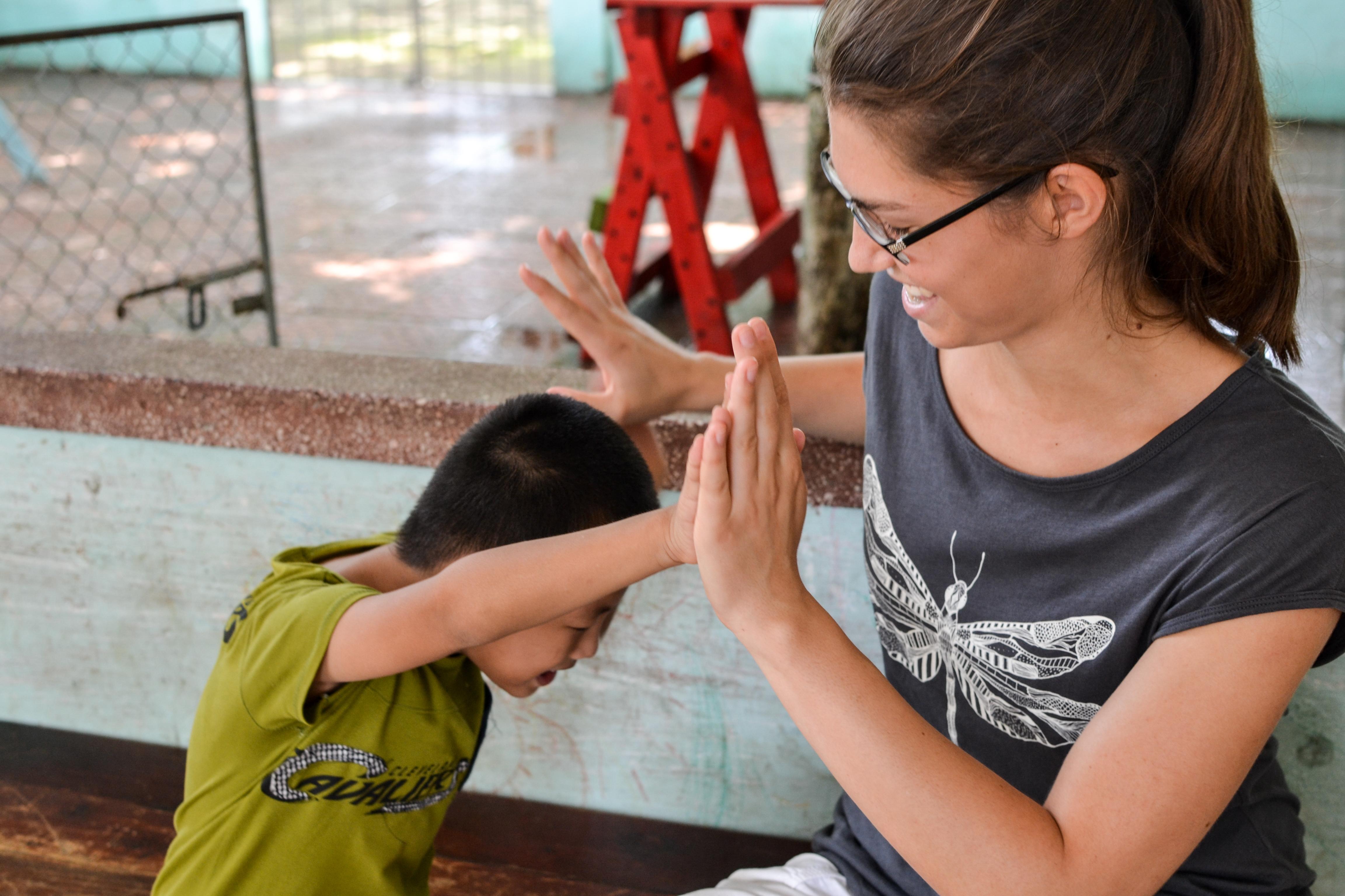 A Projects Abroad intern playing with a disabled boy during her medical internship in Vietnam, Asia. Female Projects Abroad intern can be seen playing with a young disabled boy during her medical internship in Vietnam, Asia.